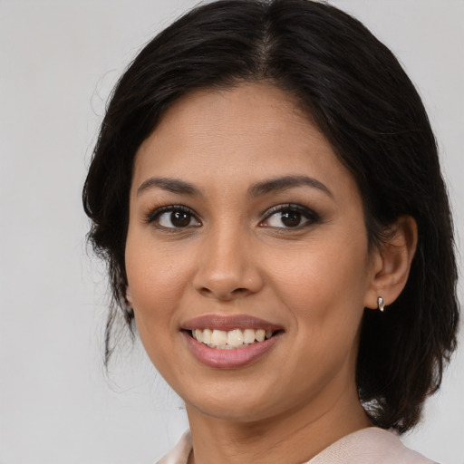 Joyful latino young-adult female with medium  brown hair and brown eyes