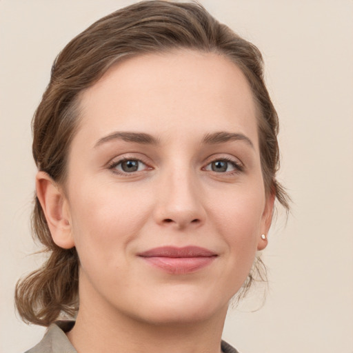 Joyful white young-adult female with medium  brown hair and grey eyes