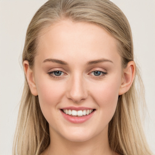 Joyful white young-adult female with long  brown hair and blue eyes