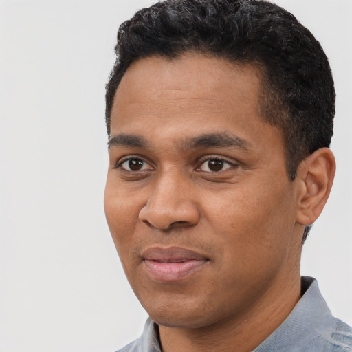 Joyful black young-adult male with short  black hair and brown eyes