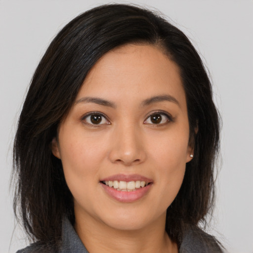 Joyful asian young-adult female with long  brown hair and brown eyes