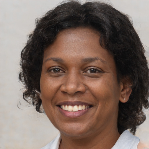 Joyful black adult female with medium  brown hair and brown eyes