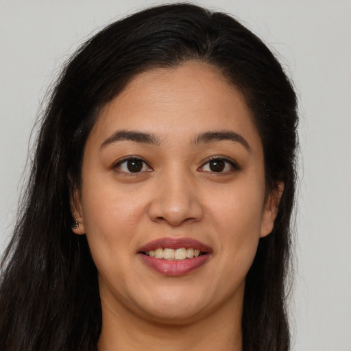 Joyful latino young-adult female with long  brown hair and brown eyes