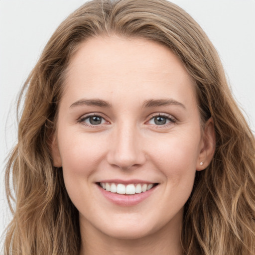 Joyful white young-adult female with long  brown hair and blue eyes