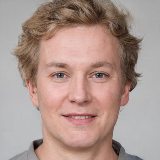 Joyful white adult male with short  brown hair and blue eyes