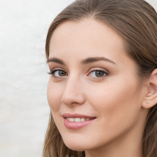 Joyful white young-adult female with long  brown hair and blue eyes