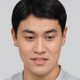 Joyful asian young-adult male with short  brown hair and brown eyes