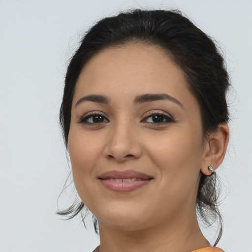 Joyful latino young-adult female with long  brown hair and brown eyes