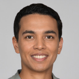 Joyful latino young-adult male with short  black hair and brown eyes