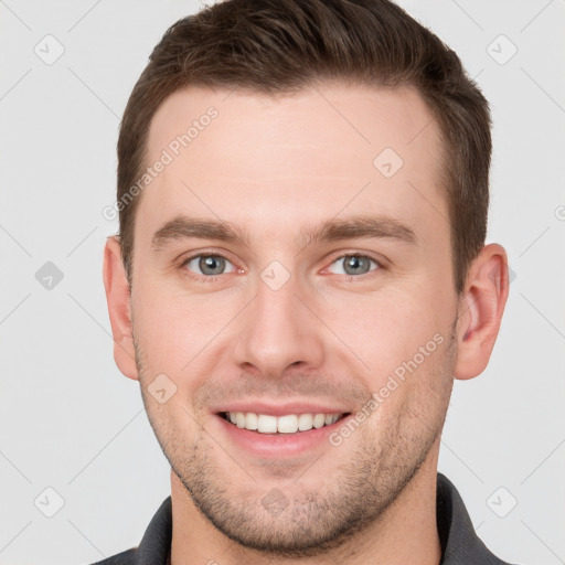 Joyful white young-adult male with short  brown hair and grey eyes