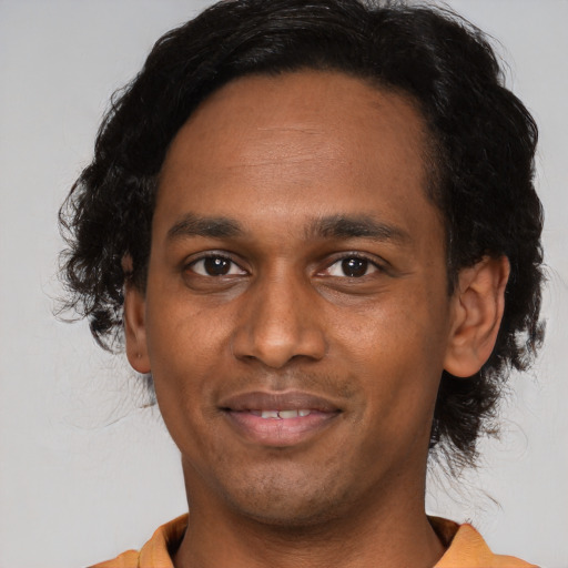 Joyful black young-adult male with short  black hair and brown eyes