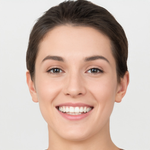 Joyful white young-adult female with short  brown hair and brown eyes