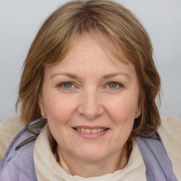 Joyful white adult female with medium  brown hair and blue eyes