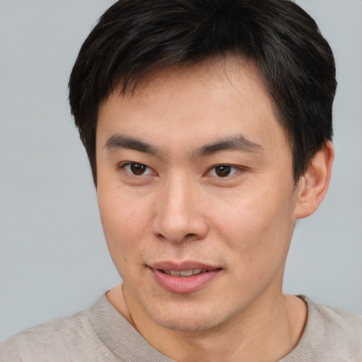 Joyful asian young-adult male with short  brown hair and brown eyes