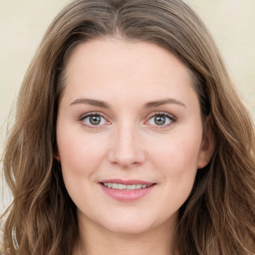 Joyful white young-adult female with long  brown hair and green eyes