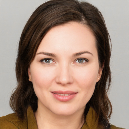 Joyful white young-adult female with medium  brown hair and green eyes