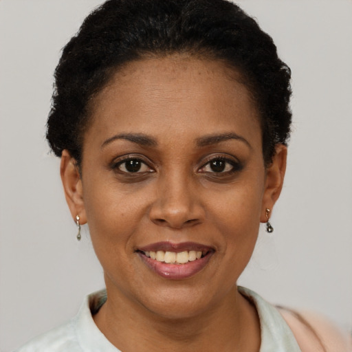Joyful black young-adult female with short  brown hair and brown eyes