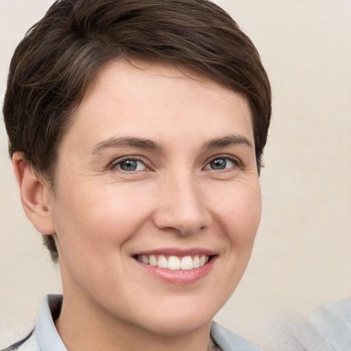 Joyful white young-adult female with short  brown hair and grey eyes