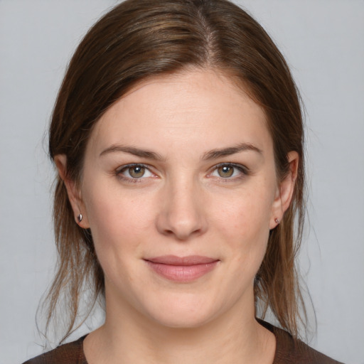 Joyful white young-adult female with medium  brown hair and grey eyes