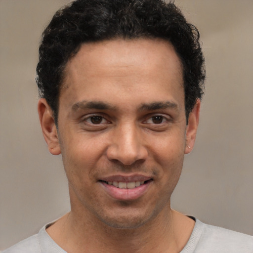 Joyful white young-adult male with short  black hair and brown eyes