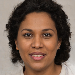 Joyful black adult female with medium  brown hair and brown eyes