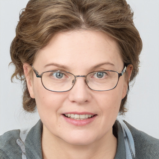 Joyful white adult female with medium  brown hair and blue eyes