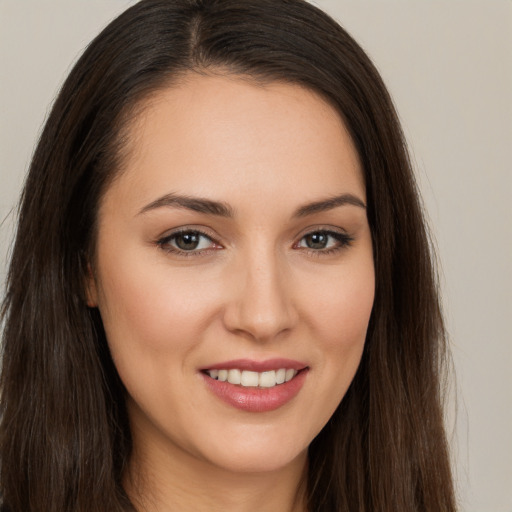 Joyful white young-adult female with long  brown hair and brown eyes