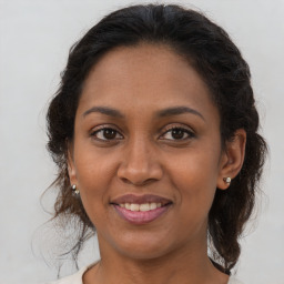 Joyful black adult female with medium  brown hair and brown eyes