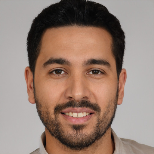 Joyful latino young-adult male with short  black hair and brown eyes