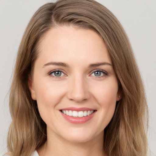 Joyful white young-adult female with long  brown hair and grey eyes