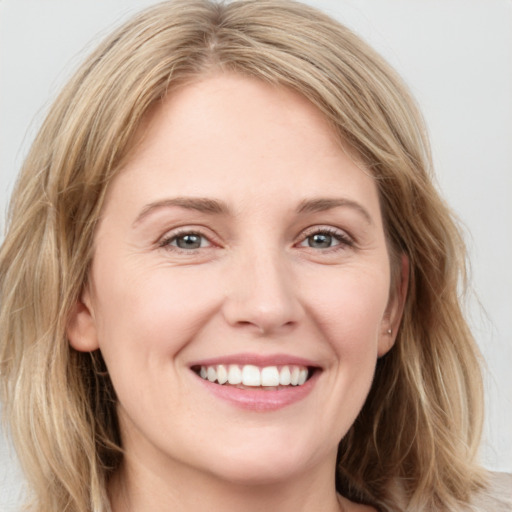 Joyful white young-adult female with medium  brown hair and blue eyes