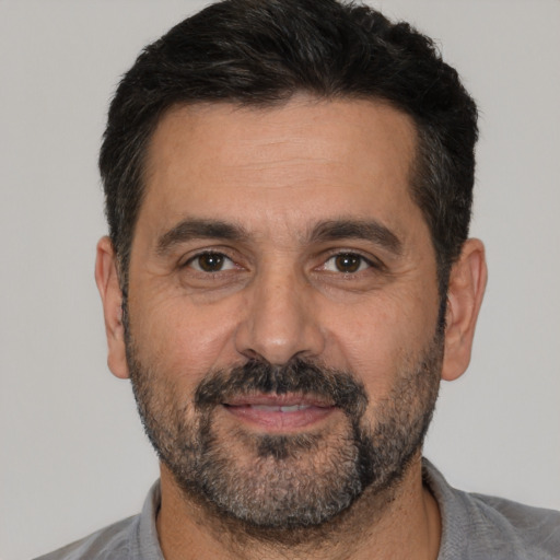 Joyful white adult male with short  black hair and brown eyes