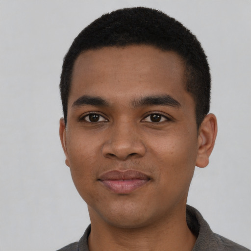 Joyful black young-adult male with short  black hair and brown eyes