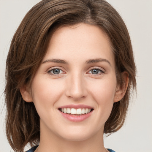 Joyful white young-adult female with medium  brown hair and green eyes