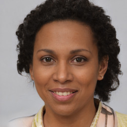 Joyful black adult female with medium  brown hair and brown eyes