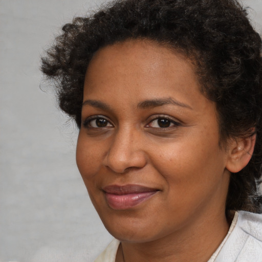 Joyful black adult female with short  brown hair and brown eyes