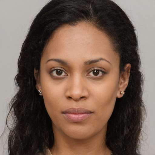 Joyful black young-adult female with long  brown hair and brown eyes