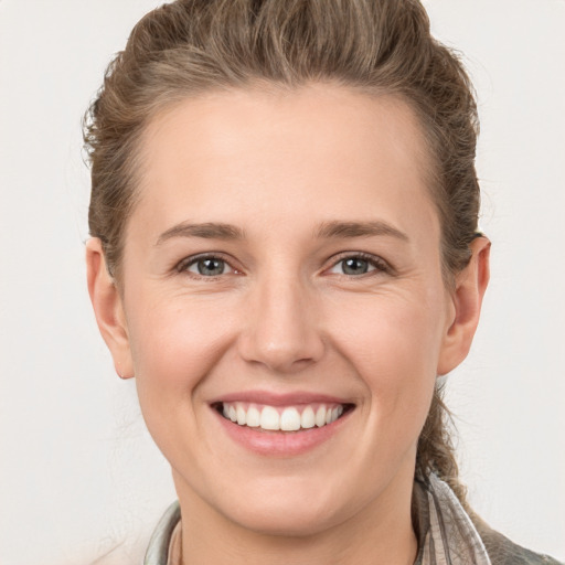 Joyful white young-adult female with short  brown hair and grey eyes