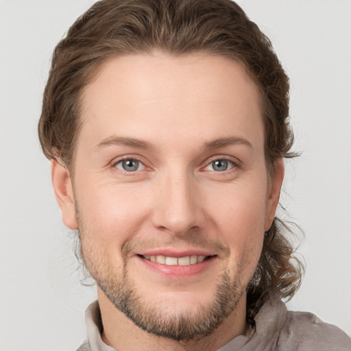 Joyful white young-adult male with short  brown hair and grey eyes