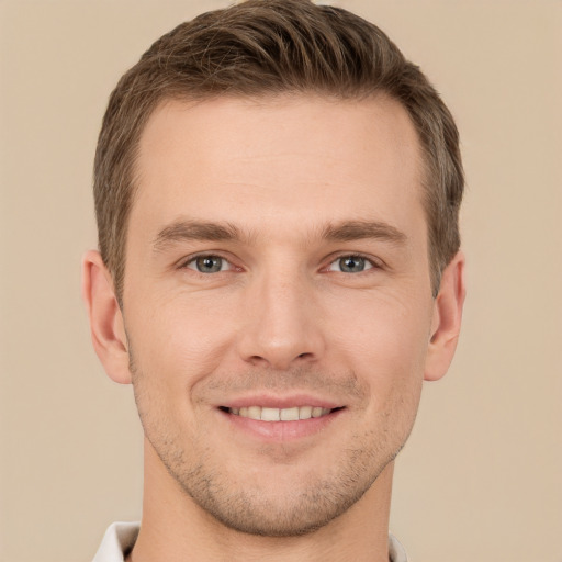 Joyful white young-adult male with short  brown hair and grey eyes