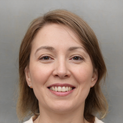 Joyful white young-adult female with medium  brown hair and grey eyes