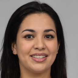 Joyful latino young-adult female with long  brown hair and brown eyes