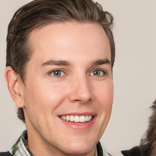 Joyful white young-adult male with medium  brown hair and grey eyes