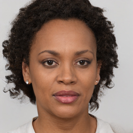 Joyful black adult female with medium  brown hair and brown eyes