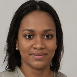 Joyful black young-adult female with long  brown hair and brown eyes