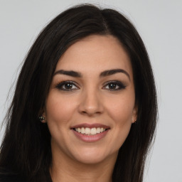 Joyful latino young-adult female with long  brown hair and brown eyes