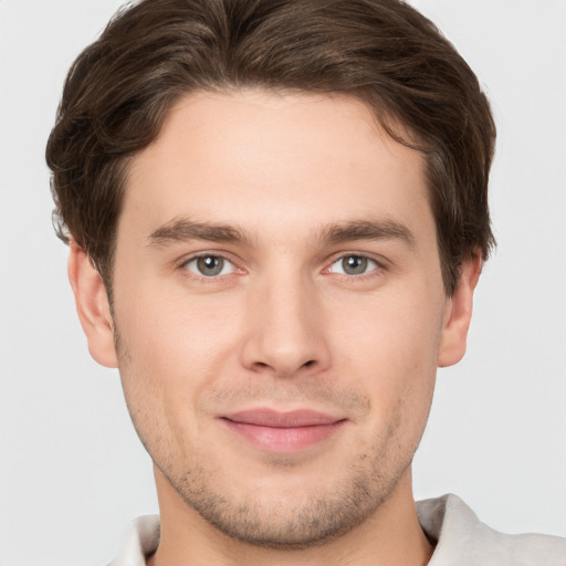 Joyful white young-adult male with short  brown hair and grey eyes