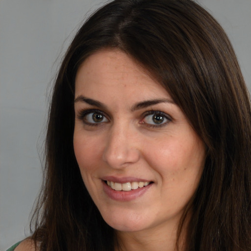 Joyful white young-adult female with long  brown hair and brown eyes