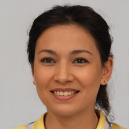 Joyful latino young-adult female with medium  brown hair and brown eyes