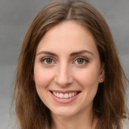 Joyful white young-adult female with long  brown hair and green eyes